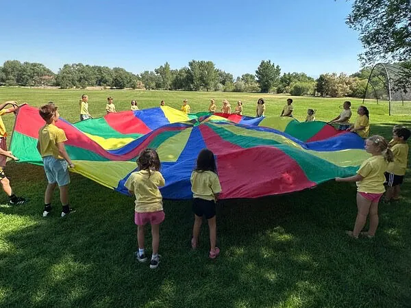 After school children playing a parachute game at the park